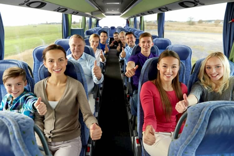 People smiling inside a charter bus