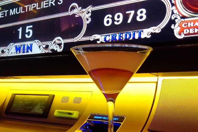 A cocktail placed in front of a slot machine