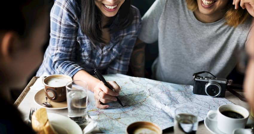 a group of campers mark a campground on a map where they want to reserve their next group camping trip 