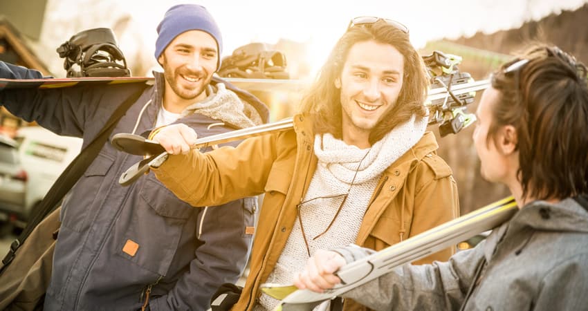 three young people holding skis