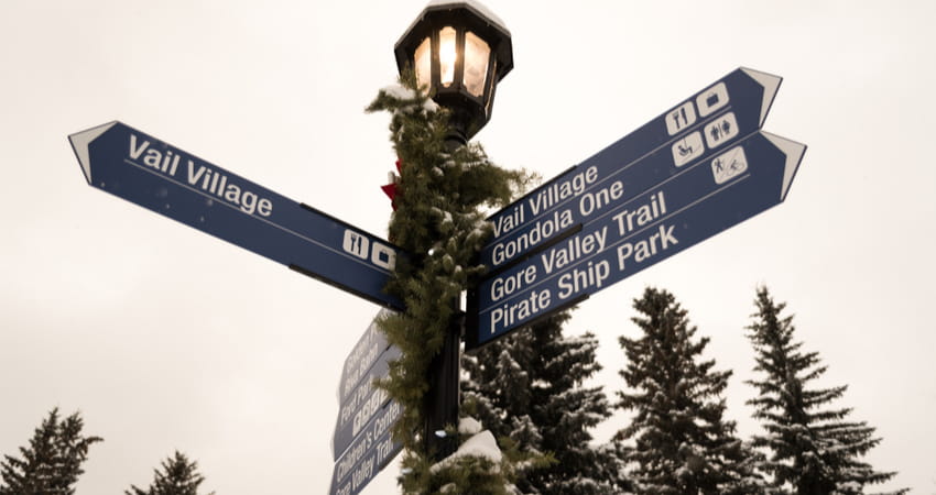 a festive street lamp with signs directing around Vail, Colorado