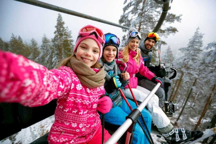 Family taking picture on ski lift