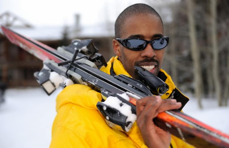 Man with skis over shoulder