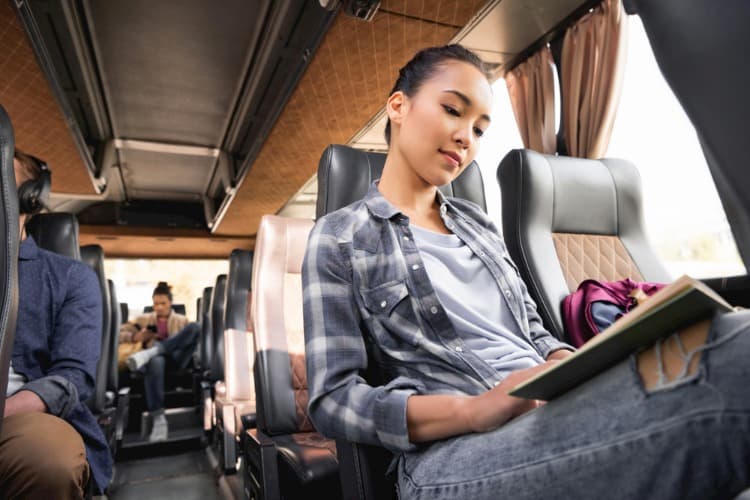 Woman reading book on bus