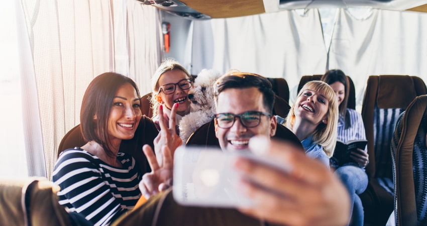 people taking a cellphone selfie photo on a minibus