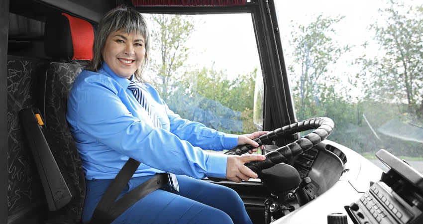 smiling bus driver behind the wheel
