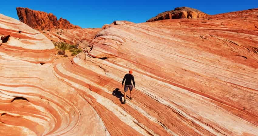 man hiking in valley fo fire state park nevada