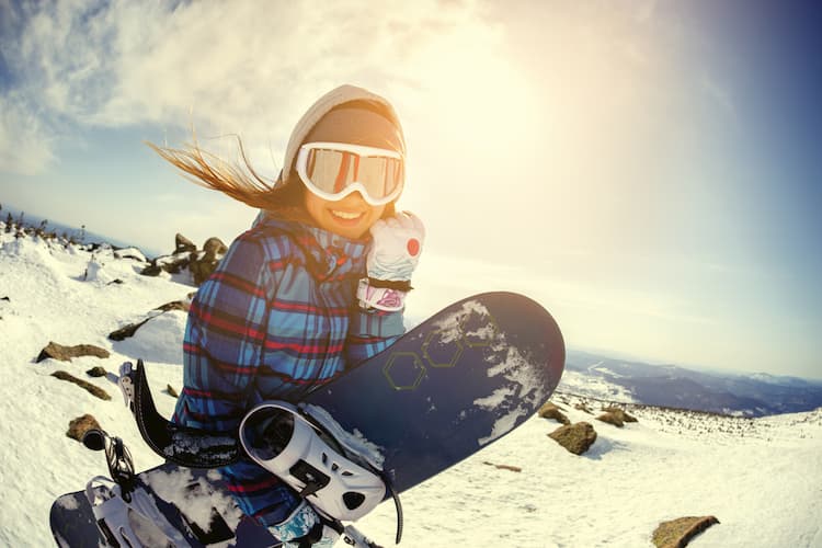 a woman smiles before heading onto a ski slope