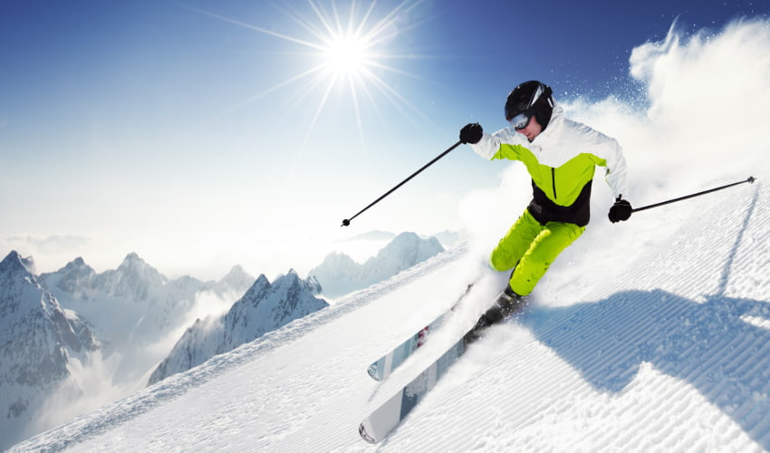 an advanced skier speeds down a powdery slope