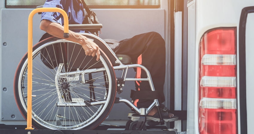 A wheelchair user boards an ADA-accessible charter bus