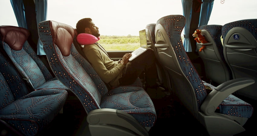 Businessman reclines with a laptop in a Las Vegas charter bus