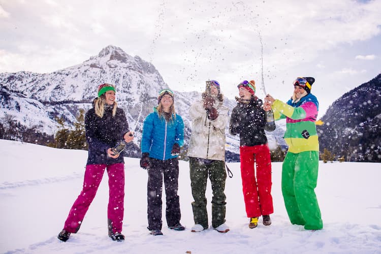 friends pop a bottle of champagne in their ski gear at stowe mountain ski resort