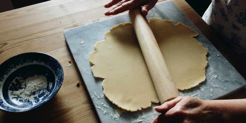 a historian rolls dough for a pie in Historic Richmond on Staten Island in new york city