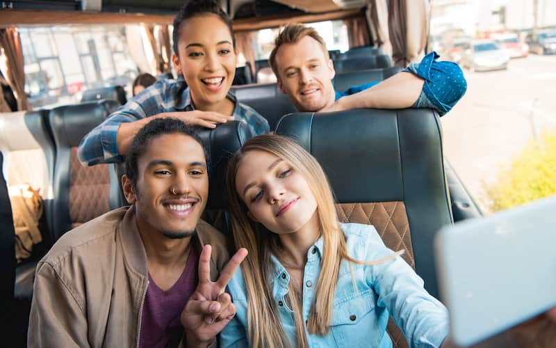 a group of friends ride in a New York City charter bus