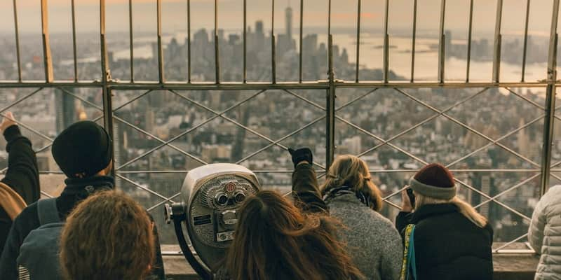 a sightseeing group admires a view on top of the empire state building in new york city