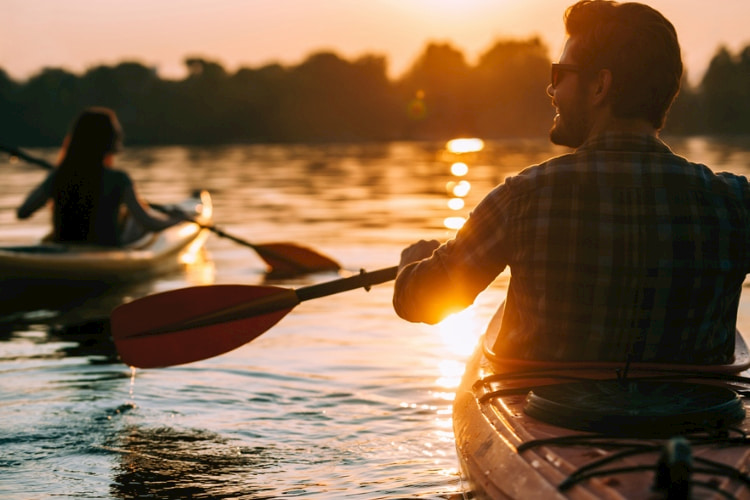 two people paddle boarding on a lake