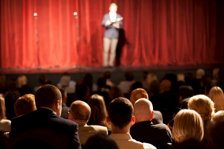A comedian performing in a room full of people