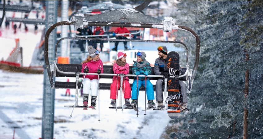 a family with two children riding a ski lift