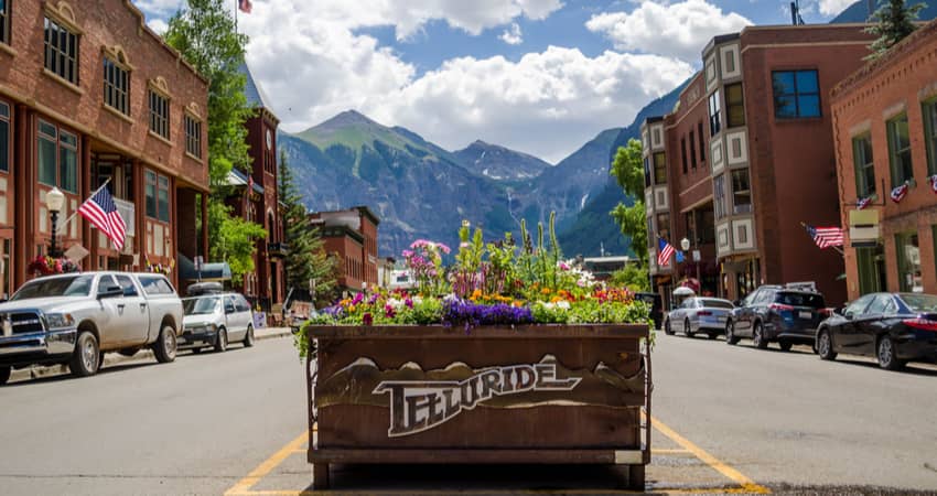 a cart of flowers in the telluride historic district with a mountain peak in the distnace