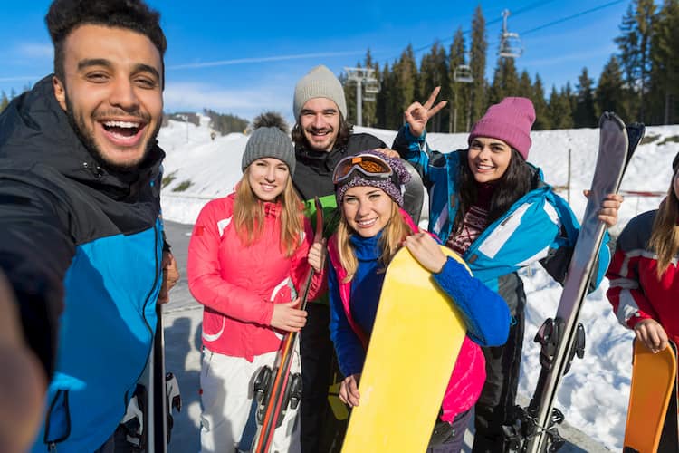 Friends taking selfie while skiing and snowboarding