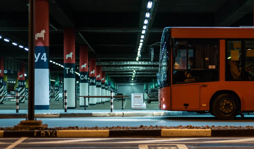 a bus pulls up to a parking deck at night