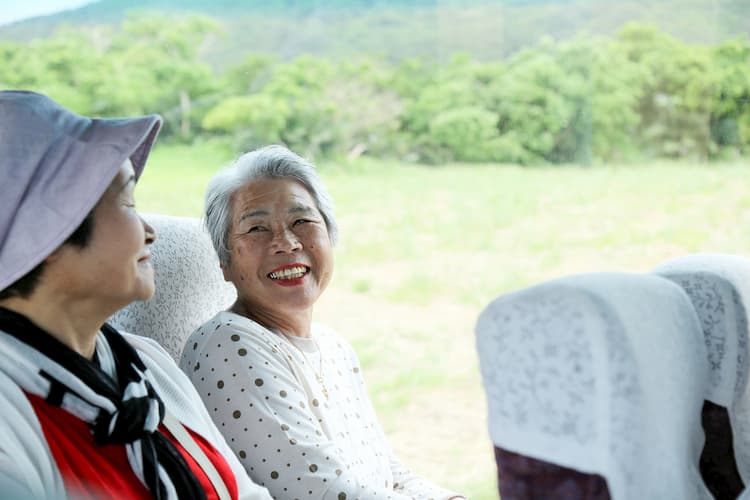 Two older women smiling on charter bus