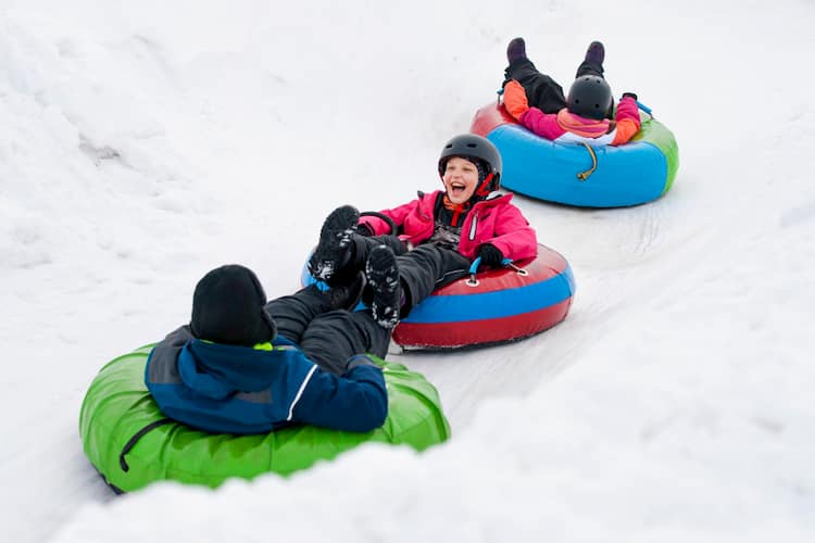 Three kids snowtubing