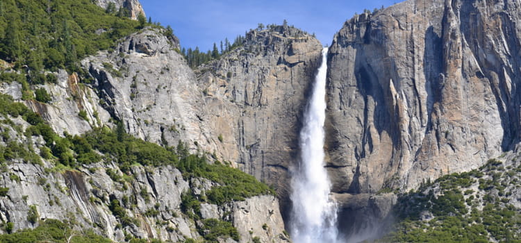 a view of yosemite falls towering over the cliffs