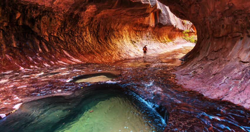A single hiker wades through the river in the Narrows in Zion National Park