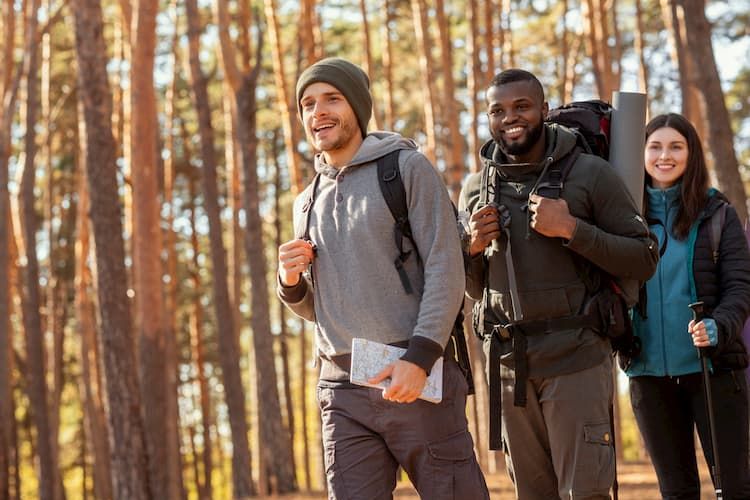 Three friends hiking through woods