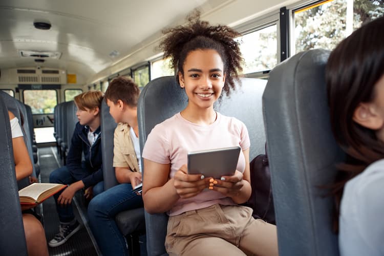 Young girl on bus with tablet