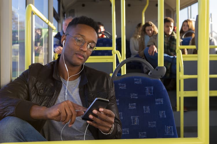 Man listening to music with earphones on bus