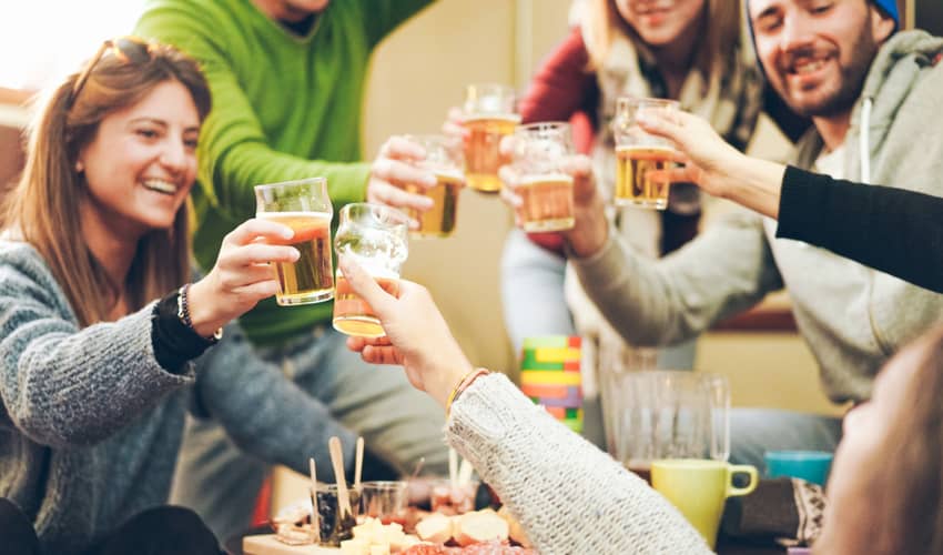 A group of friends toasting drinks after skiing 