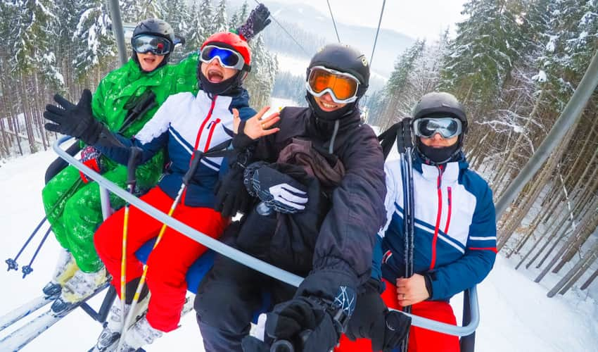 A group of people smiling for selfie on a ski lift