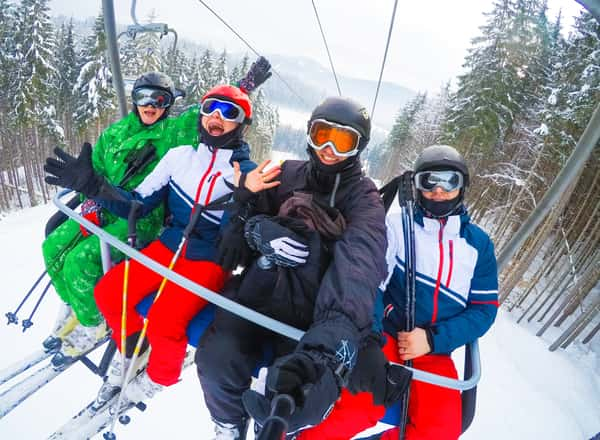 A group of people smiling for a selfie on a ski lift