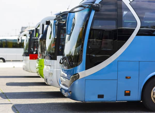 A line of charter buses parked at a lot