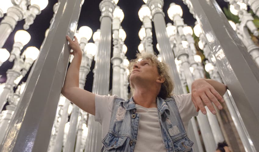 A man poses amidst the Urban Light installation at LACMA