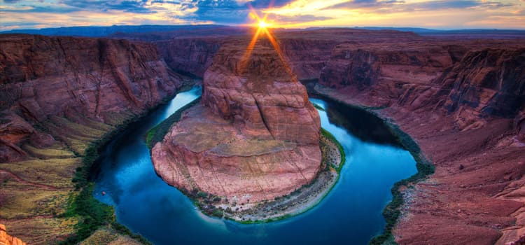 a half-circle shaped waterway sits at the base of a corner of the grand canyon