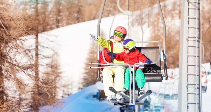 An adult and child on a ski lift