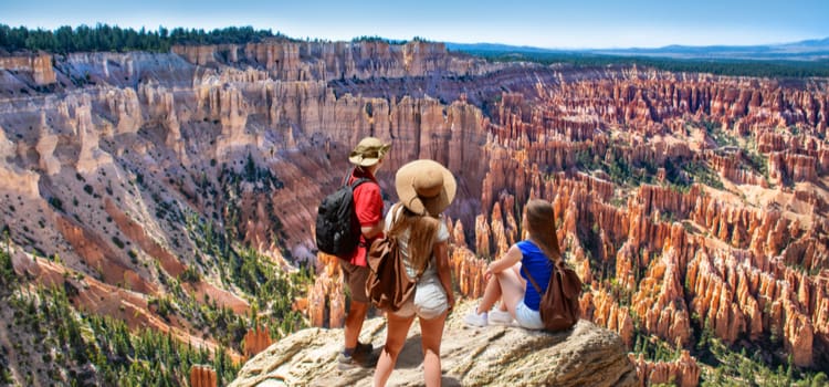 friends stand and look over the craggy rocks of the vast bryce canyon