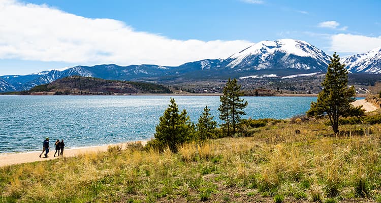 A group of campers walk around a lake in Rocky Mountain National Park