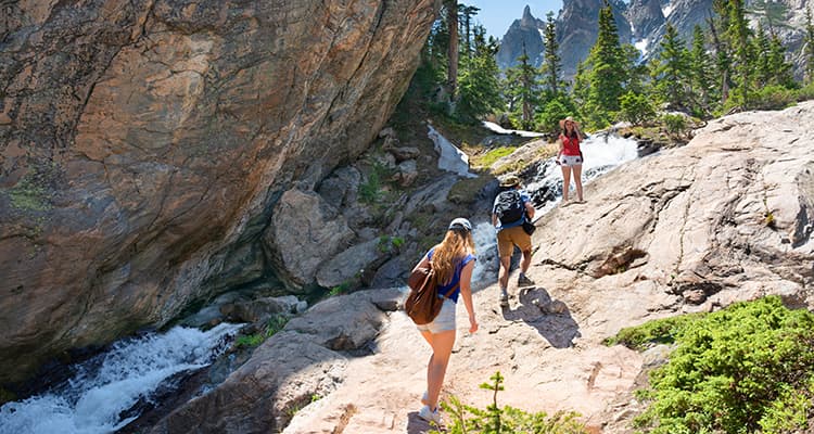 A group of hikers climb a steep hill in Rocky Mountain National Park