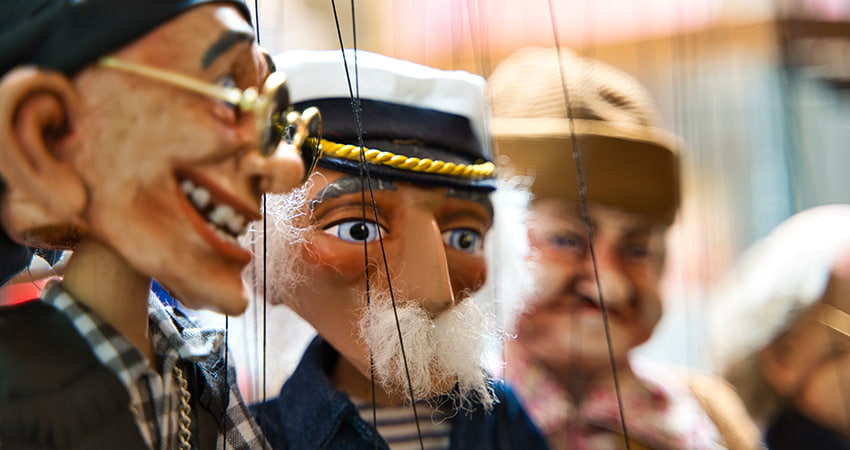 A lineup of marionettes backstage