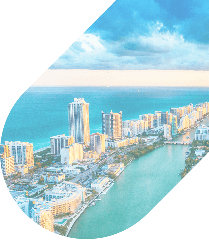 an aerial view of tall buildings and beaches in Miami on a sunny day
