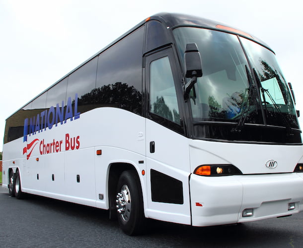 a plain white charter bus with a blue and red "national charter bus" logo