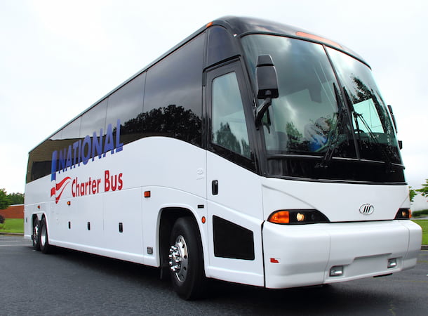 a white charter bus with a blue and red "national charter bus" logo on the side