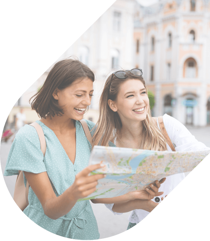 two friends smile and look at a map in an old city