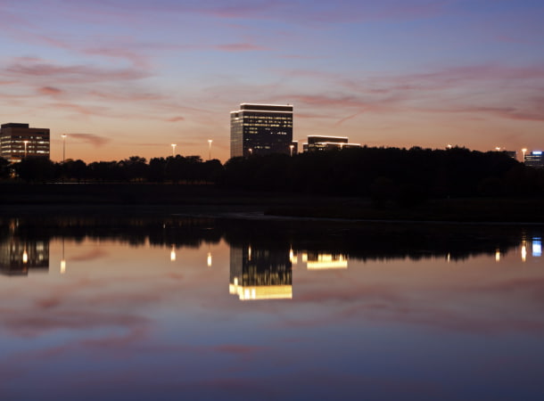 a view across a river of a tall schaumburg building at night