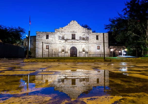 The entrance to The Alamo lit up in the evening.