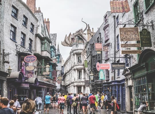 A busy city facade at Universal Studios, with theme park visitors crowding in the streets